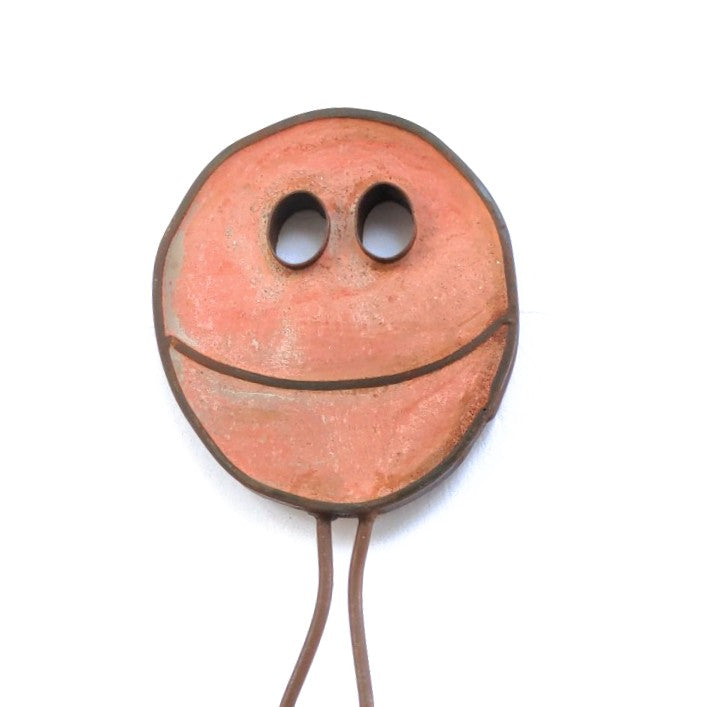 Terra cotta colored steel and concrete Happy Pill by Mark Clark.