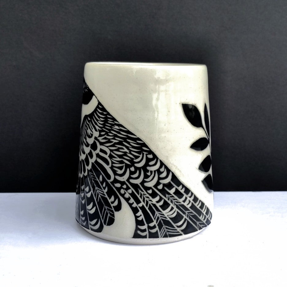 Part of bird design on White clay mug with carved black bird and branch design, pottery by Amanda Kerr