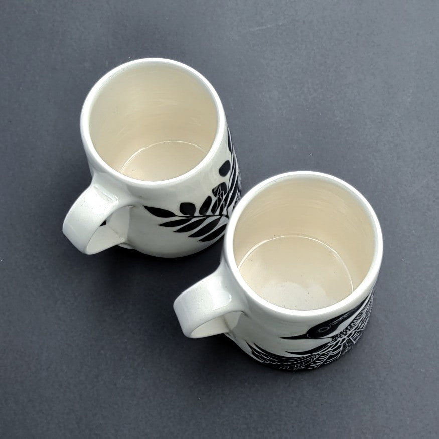 top view of White clay mug with carved black bird and branch design, pottery by Amanda Kerr