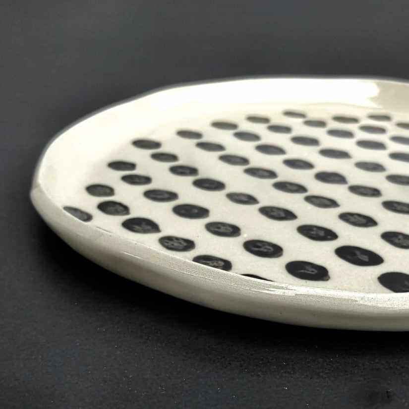 side view of Dotted pattern hand built white clay plate by Juliet Promnitz