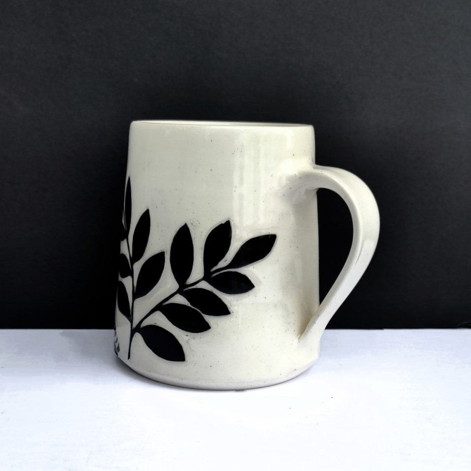 another view of White clay mug with carved black bird and branch design, pottery by Amanda Kerr