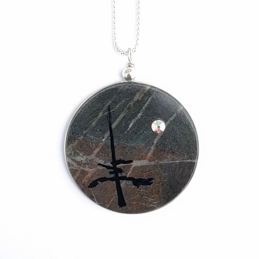 A thin slice of solid rock makes up this pendant, created by Wendy Stanwick of A Slice of the North Jewellery. Swarovski Crystal and hand painted tree design