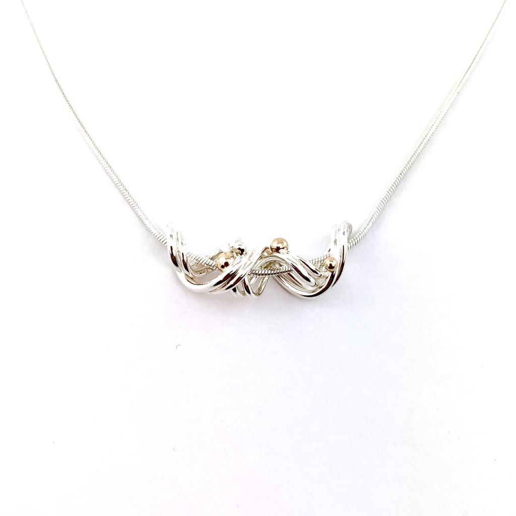 Sterling Silver  with 14 karat gold accents, twisted handcrafted pendant design by Lynda Constantine